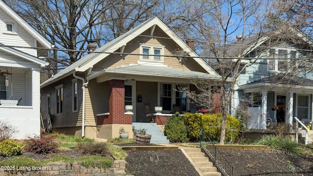 view of front facade featuring brick siding and a porch
