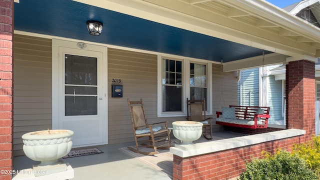 property entrance featuring brick siding and covered porch