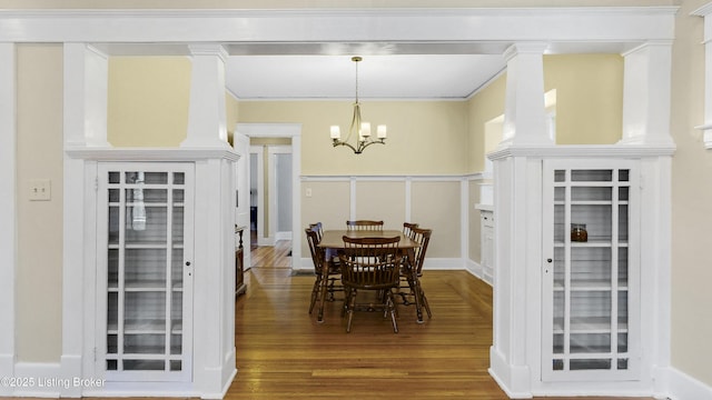 dining room featuring ornamental molding, wood finished floors, and a chandelier