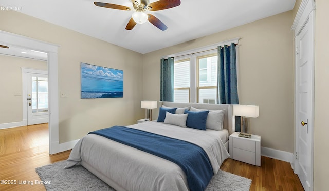 bedroom featuring ceiling fan, baseboards, and wood finished floors