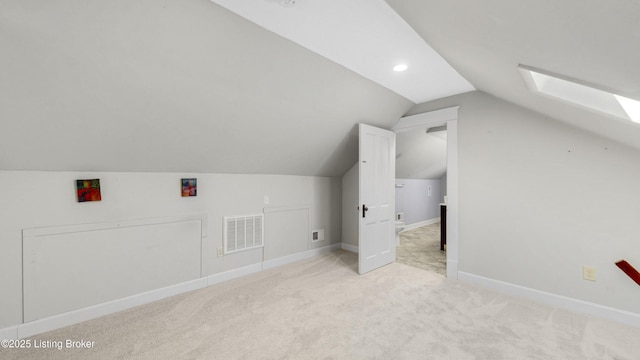 additional living space with lofted ceiling with skylight, visible vents, baseboards, and carpet