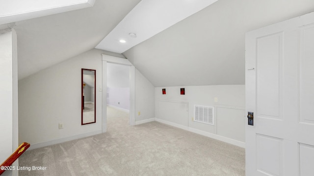 additional living space featuring visible vents, baseboards, lofted ceiling, and carpet