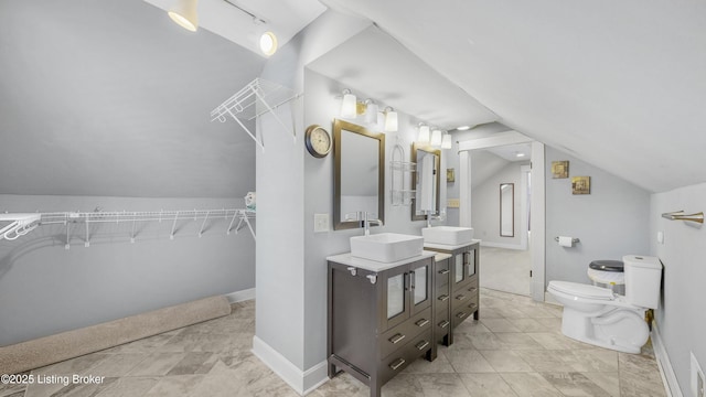 full bath with vanity, lofted ceiling, toilet, and baseboards