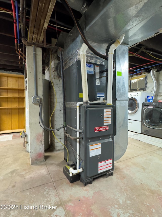 utility room featuring heating unit and washer and dryer