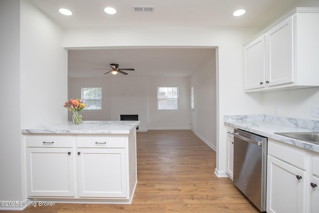 3833 Jupiter Rd, Louisville, KY 40218 - kitchen with dishwasher, ceiling fan, light wood-style flooring, white cabinets, and a large fireplace