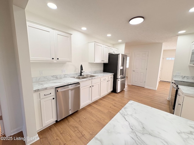 3833 Jupiter Rd, Louisville, KY 40218 - kitchen with stainless steel appliances, a sink, light wood finished floors, white cabinetry, and recessed lighting