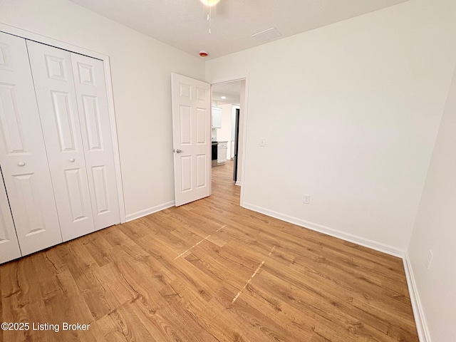 3833 Jupiter Rd, Louisville, KY 40218 - unfurnished bedroom with light wood finished floors, baseboards, and a closet