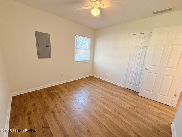3833 Jupiter Rd, Louisville, KY 40218 - unfurnished bedroom with electric panel, light wood-type flooring, baseboards, and a closet