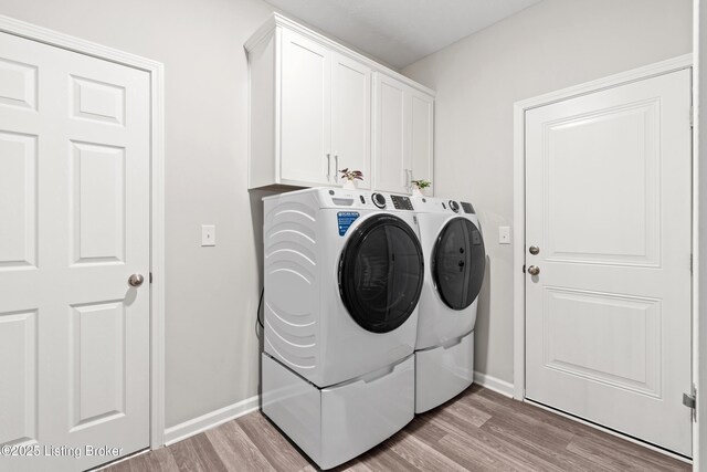 8806 Warbler Branch Way, Louisville, KY 40229 - laundry area featuring light wood-type flooring, cabinet space, baseboards, and washing machine and clothes dryer