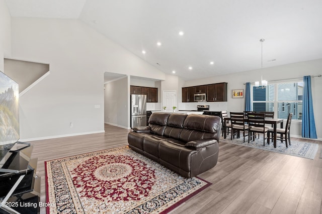 8806 Warbler Branch Way, Louisville, KY 40229 - living room with a notable chandelier, high vaulted ceiling, recessed lighting, light wood finished floors, and baseboards