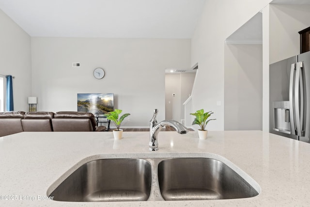 8806 Warbler Branch Way, Louisville, KY 40229 - kitchen with visible vents, stainless steel fridge with ice dispenser, light stone countertops, open floor plan, and a sink