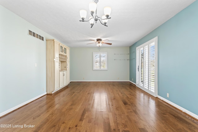 6709 Wild Fox Ln, Prospect, KY 40059 - spare room featuring wood finished floors, baseboards, visible vents, and ceiling fan with notable chandelier