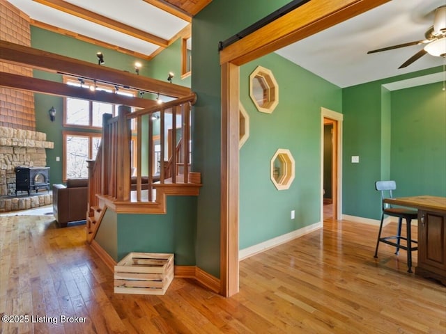 stairs featuring hardwood / wood-style floors, baseboards, and ceiling fan