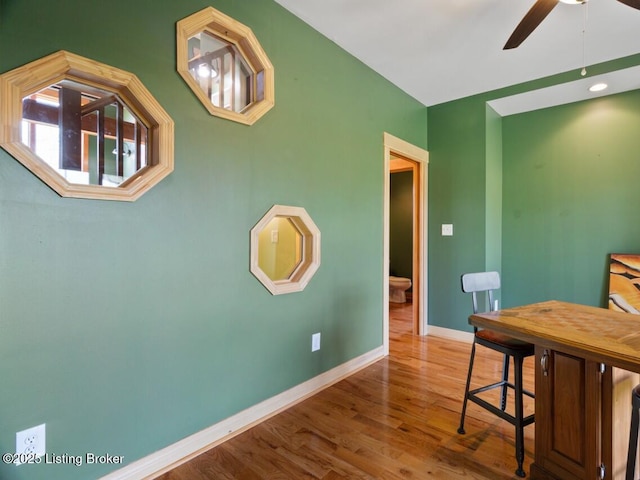 dining space with baseboards, wood finished floors, and ceiling fan