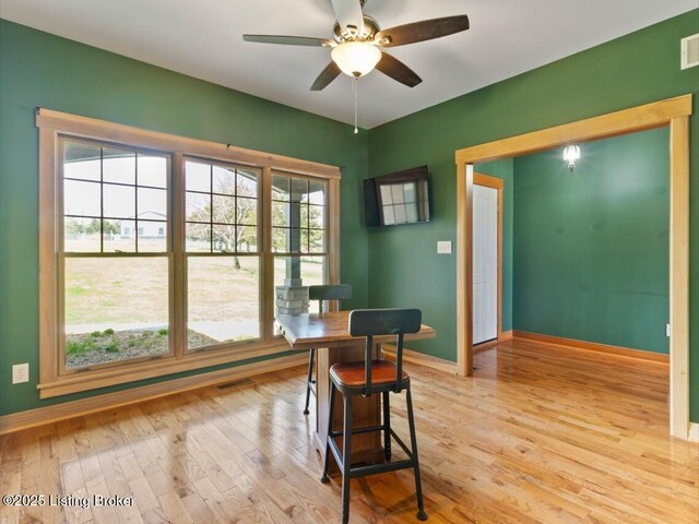 dining area featuring a wealth of natural light, light wood-style flooring, ceiling fan, and baseboards