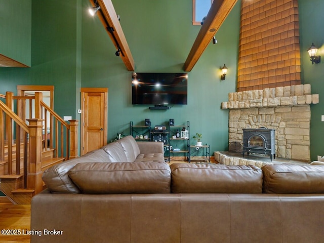 living area featuring stairs, a high ceiling, track lighting, and wood finished floors