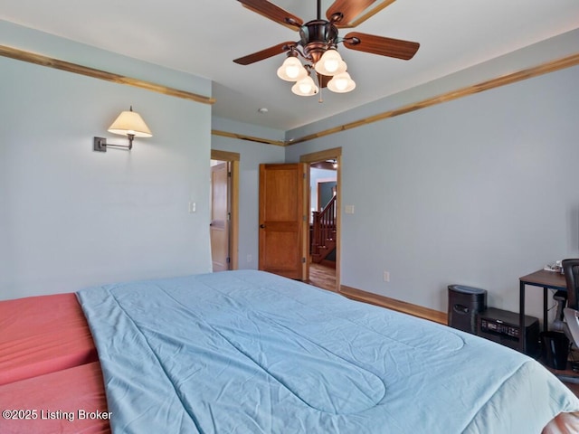 bedroom with baseboards, wood finished floors, and a ceiling fan