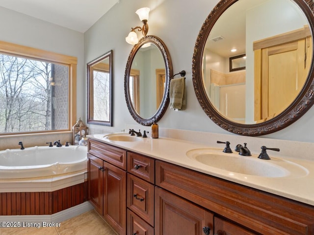 bathroom with double vanity, a sink, visible vents, and a bath