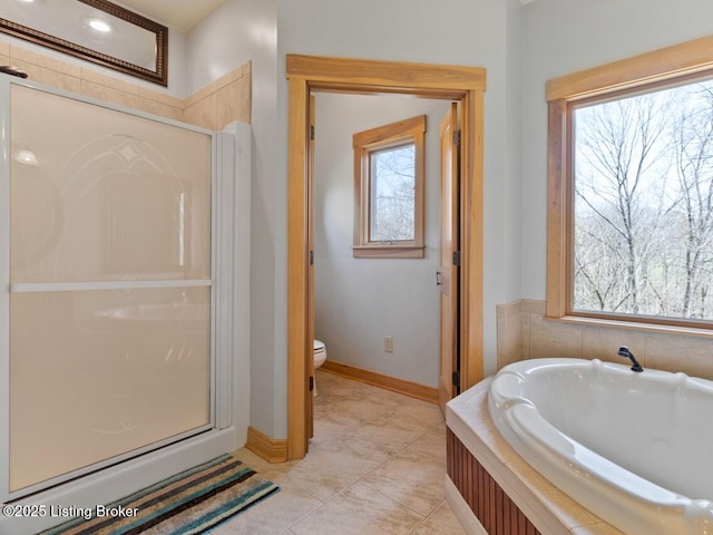 full bathroom with a healthy amount of sunlight, a garden tub, and a shower stall