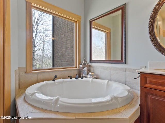bathroom with vanity, a healthy amount of sunlight, and a bath