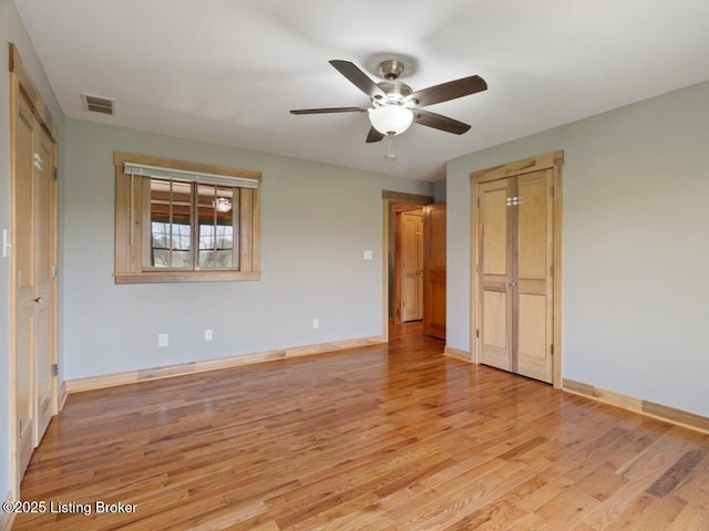 unfurnished bedroom featuring baseboards, visible vents, light wood-style flooring, and a ceiling fan