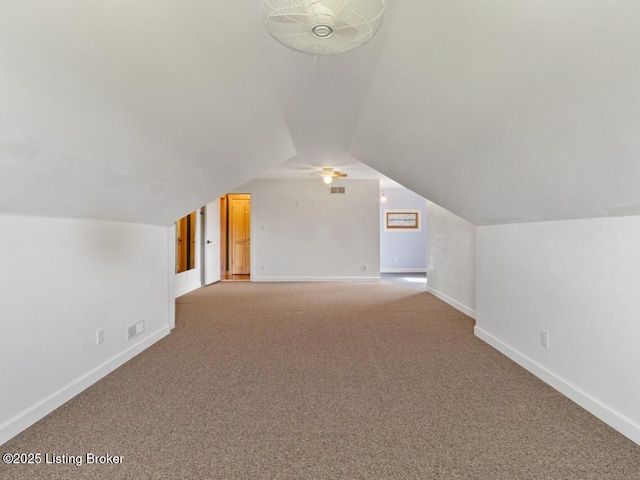 additional living space featuring carpet flooring, a ceiling fan, baseboards, and lofted ceiling