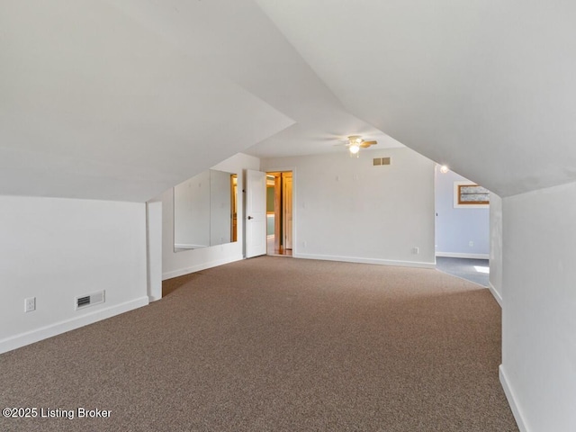 additional living space featuring carpet, baseboards, lofted ceiling, and visible vents