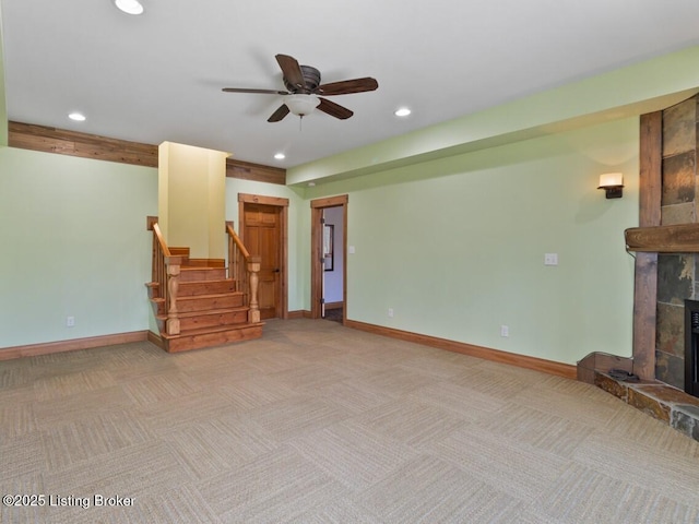 living room with light colored carpet, recessed lighting, baseboards, ceiling fan, and a fireplace