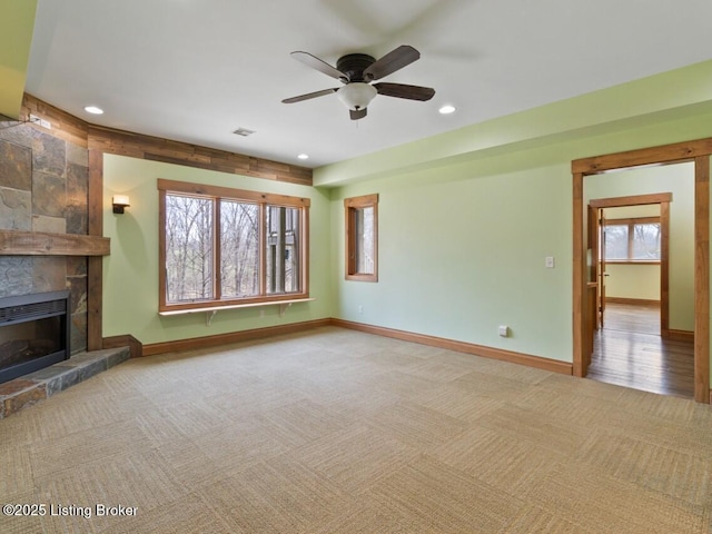 unfurnished living room featuring a tiled fireplace, carpet flooring, baseboards, ceiling fan, and recessed lighting