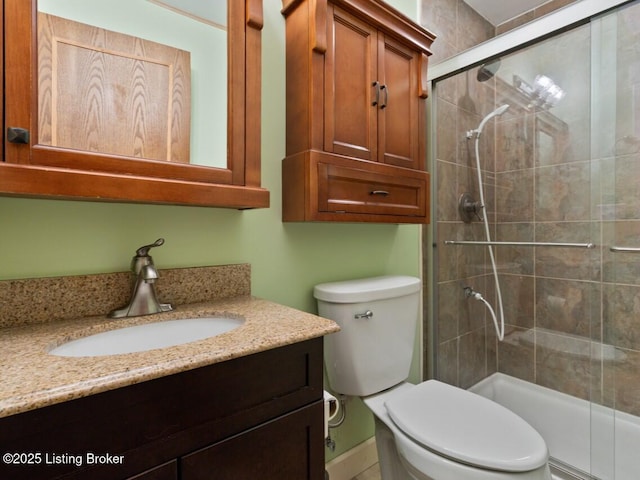 bathroom featuring toilet, a stall shower, and vanity