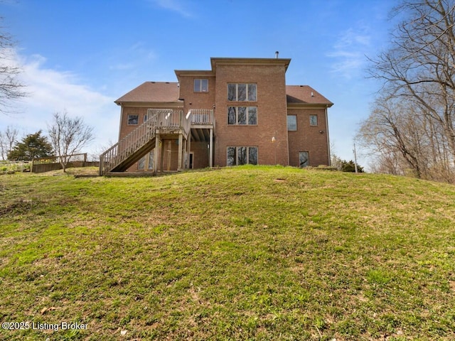 back of house featuring stairs, a deck, and a lawn