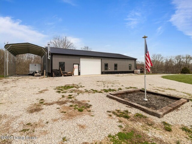 view of outdoor structure with a detached carport, gravel driveway, and an outbuilding