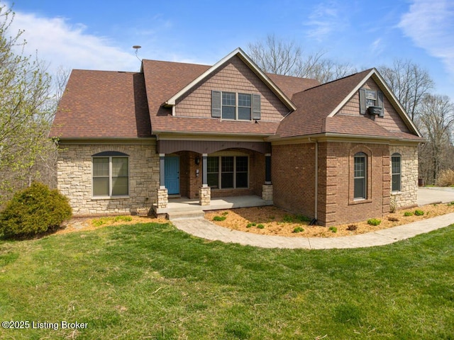craftsman-style home featuring a front yard, a porch, stone siding, and roof with shingles