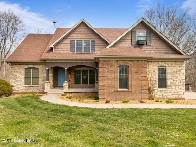 craftsman house featuring a shingled roof, a front yard, a porch, and stone siding