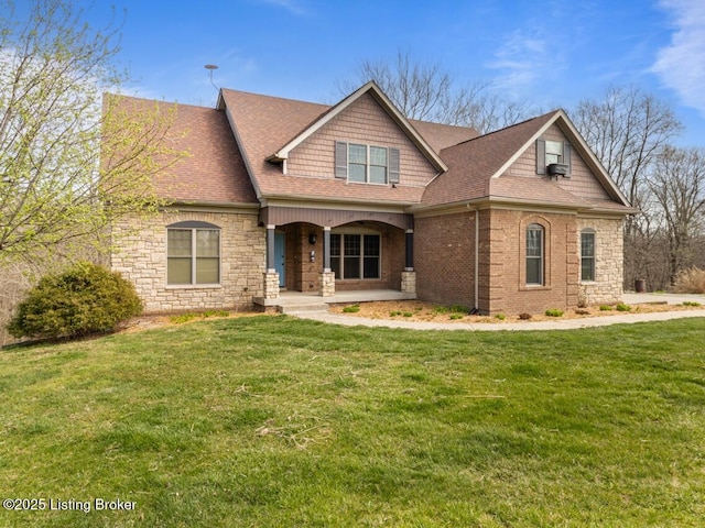 craftsman house featuring stone siding, covered porch, roof with shingles, and a front yard