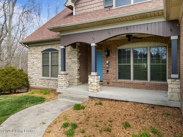 property entrance featuring covered porch, a ceiling fan, stone siding, and roof with shingles