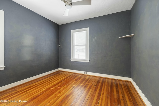 spare room with baseboards, ceiling fan, and wood-type flooring