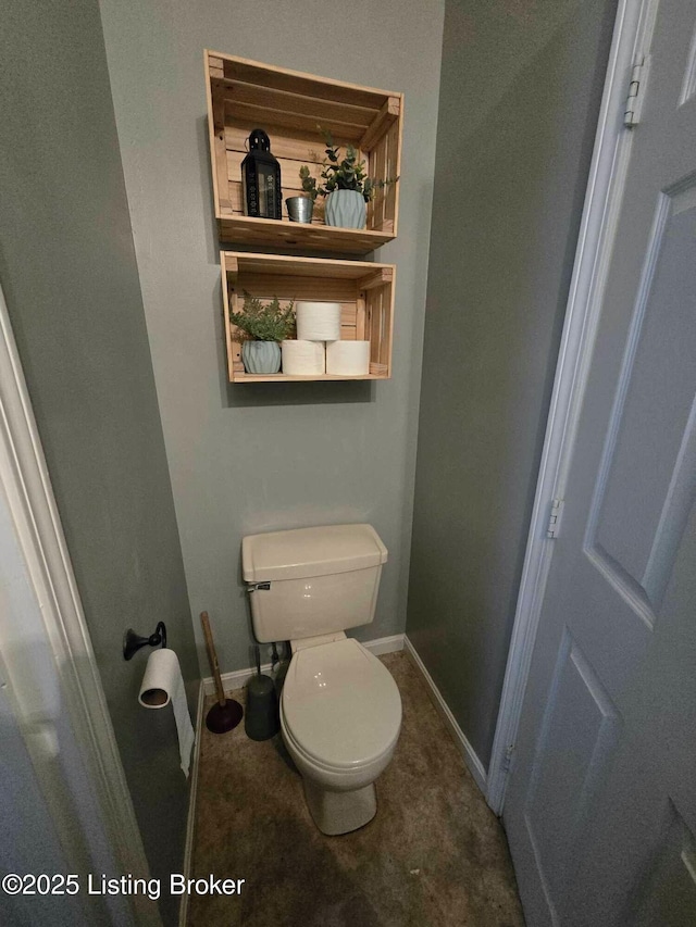 bathroom featuring toilet and baseboards