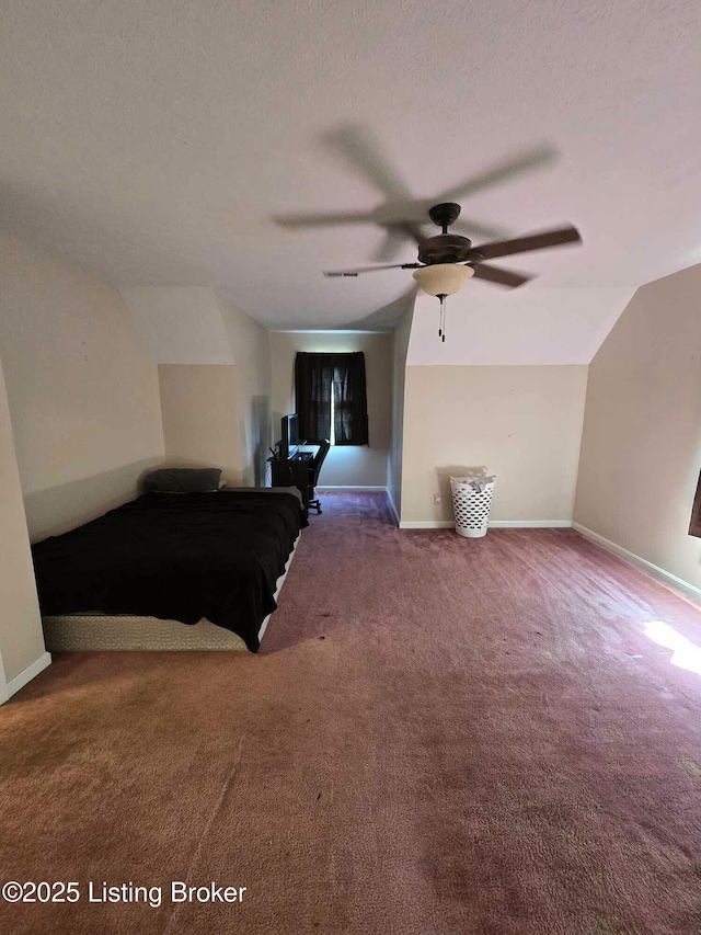 unfurnished bedroom with baseboards, carpet floors, a textured ceiling, and vaulted ceiling