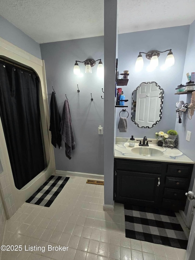 full bath featuring vanity, baseboards, visible vents, a textured ceiling, and curtained shower