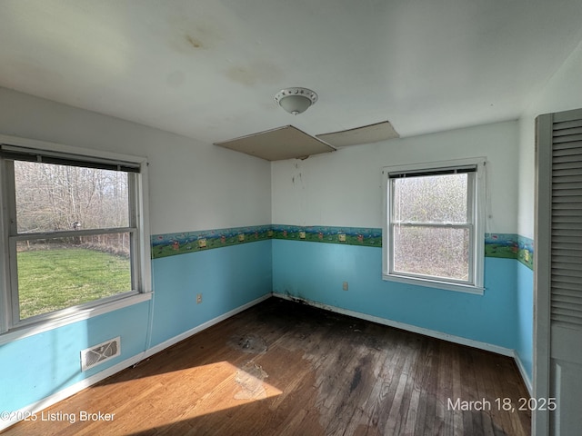 7725 3rd Street Rd, Louisville, KY 40214 - spare room featuring visible vents, a healthy amount of sunlight, baseboards, and wood finished floors