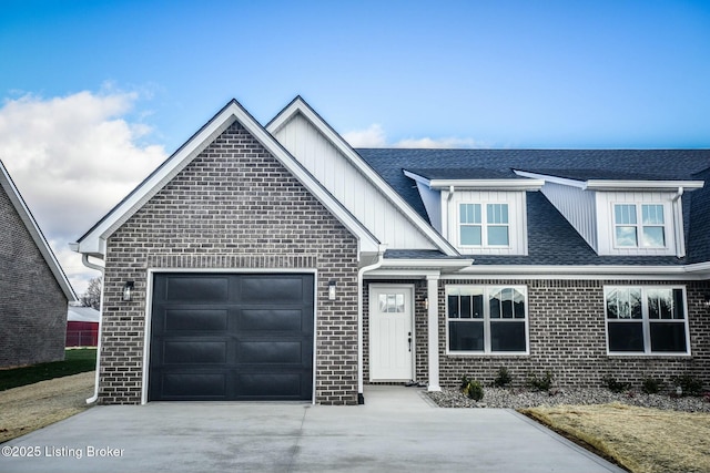 view of front of house with an attached garage, brick siding, board and batten siding, and driveway