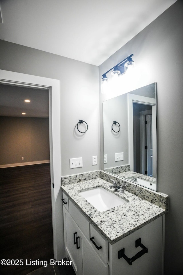 bathroom featuring vanity, wood finished floors, and baseboards