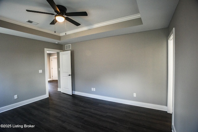 spare room featuring visible vents, ornamental molding, a ceiling fan, baseboards, and dark wood-style flooring