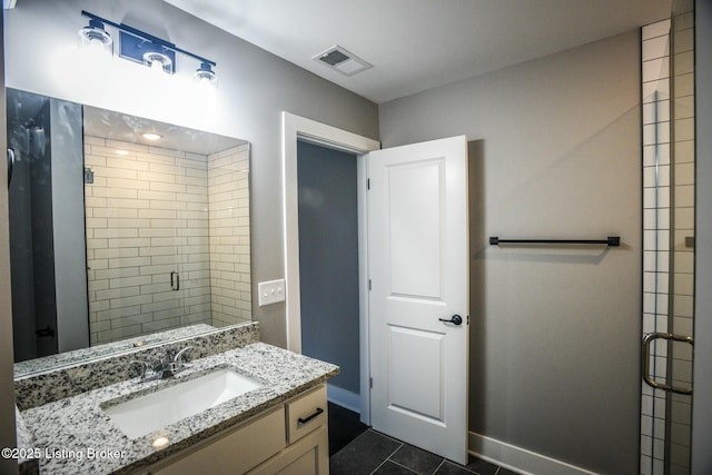 full bath featuring vanity, baseboards, visible vents, a shower stall, and tile patterned floors