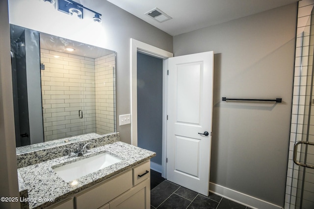 bathroom featuring tile patterned flooring, visible vents, baseboards, a stall shower, and vanity