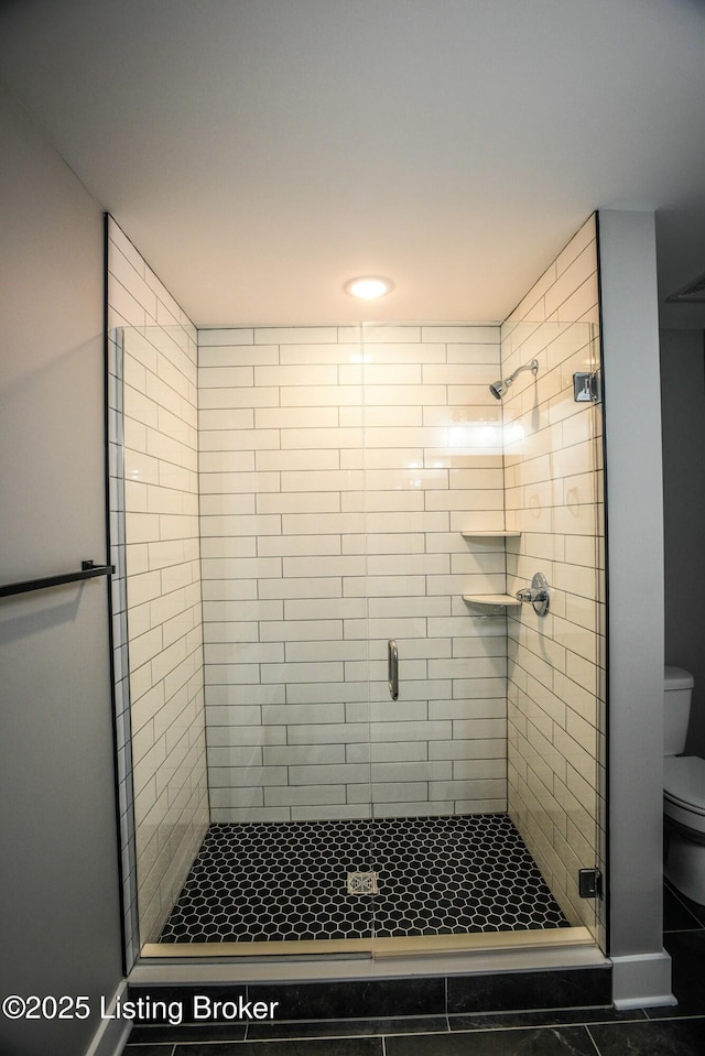 full bathroom featuring a stall shower and toilet