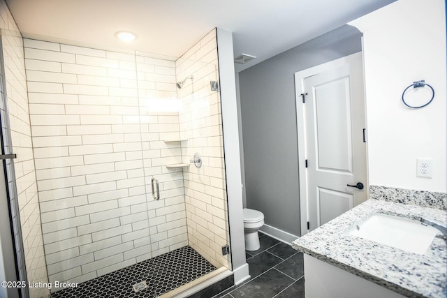 full bath with visible vents, a shower stall, baseboards, toilet, and vanity