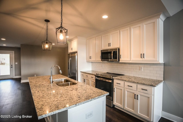 kitchen with backsplash, appliances with stainless steel finishes, white cabinetry, and a sink