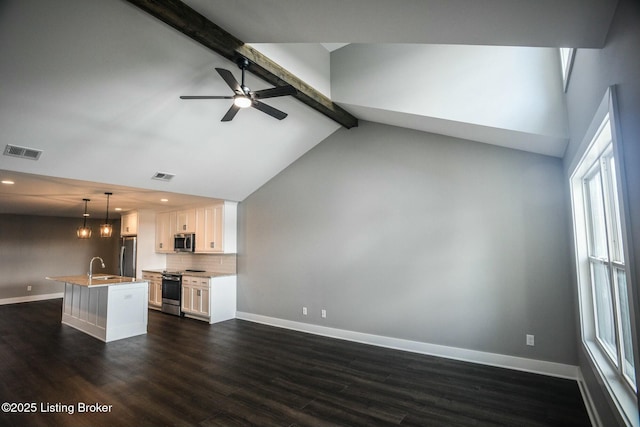 kitchen featuring beamed ceiling, baseboards, visible vents, and stainless steel appliances